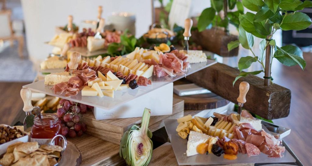 A beautifully arranged buffet table featuring an assortment of cheese, meats, and fresh fruits for a delightful spread.